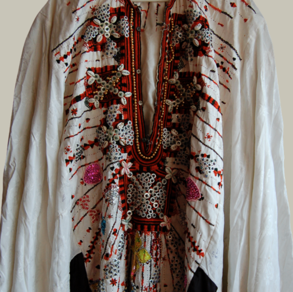The chest panel of a Siwa dress, showing an embroidered necklace with square amulets